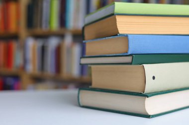 Kütüphanedeki masanın üzerinde kitap yığını