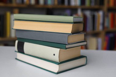 Kütüphanedeki masanın üzerinde kitap yığını