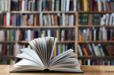 Masanın üzerinde ciltli kitap olan açık bir kitap
