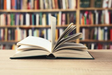 Açık kitap, ahşap masa üzerinde kitaplar, kütüphanenin arka planı. Okuldaki raflarda kitaplar, ahşap masanın üzerinde açık kitap. Okul konseptine geri dönüş, yüksek kaliteli kitap fotoğrafçılığı, en iyi kitap fotoğrafı, en ünlü Alman yazarlar, Almanya