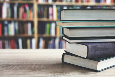 Kütüphanede ahşap arka plan üzerine bir yığın kitap, düzgünce düzenlenmiş kitaplar. Kütüphanelerdeki rafların çoğunda kitabın omurgasında (numaralar, kodlar veya etiketler) net işaretler bulunan boy, konu veya türe göre düzenlenmiş kitaplar vardır. Kütüphaneler sessiz yerlerdir.