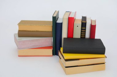 Beyaz arkaplan üzerine renkli kitap yığını
