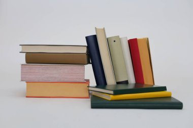 Beyaz arkaplan üzerine bir yığın kitap, ahşap masa, okula dönüş, farklı boyutlarda kitaplar, kütüphanede kitap yığını, metin, eğitim, okul, yapay zeka