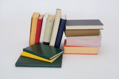 Beyaz arkaplan üzerine bir yığın kitap, ahşap masa, okula dönüş, farklı boyutlarda kitaplar, kütüphanede kitap yığını, metin, eğitim, okul, yapay zeka