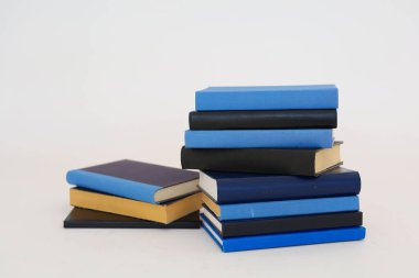 Beyaz arkaplanda izole edilmiş kitap yığınları. Kütüphanenin arka planına karşı kitap yığınları, kütüphanenin önündeki kitap yığınları, ahşap masa, eğitim, yüksek kaliteli kitap fotoğrafçılığı, En İyi Kitap Fotoğrafı, AI, Viyana; Longford;