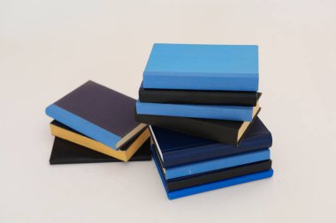 Beyaz arkaplanda izole edilmiş kitap yığınları. Kütüphanenin arka planına karşı kitap yığınları, kütüphanenin önündeki kitap yığınları, ahşap masa, eğitim, yüksek kaliteli kitap fotoğrafçılığı, En İyi Kitap Fotoğrafı, AI, Viyana; Longford;