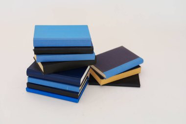 Beyaz arkaplanda izole edilmiş kitap yığınları. Kütüphanenin arka planına karşı kitap yığınları, kütüphanenin önündeki kitap yığınları, ahşap masa, eğitim, yüksek kaliteli kitap fotoğrafçılığı, En İyi Kitap Fotoğrafı, AI, Viyana; Longford;