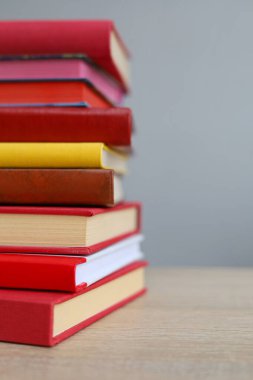 Ahşap masanın üzerinde bulanık arka plana karşı bir yığın kitap. Metin için boşluk