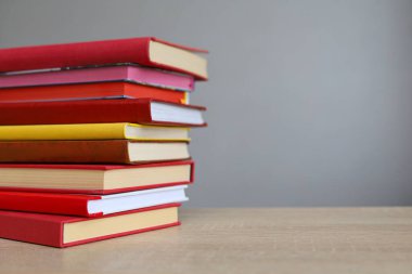 Kütüphanedeki ahşap masada yığınla kitap.