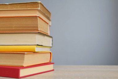 Tahta masadaki kitap yığını.