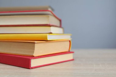 Tahta masadaki kitap yığını.