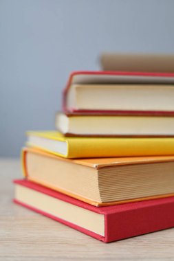 Kütüphanedeki ahşap masanın üzerinde bir yığın kitap.