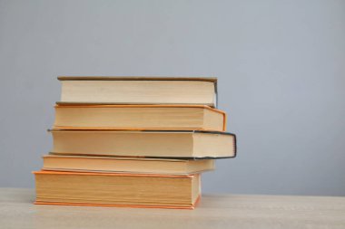 Tahta masadaki kitap yığını.