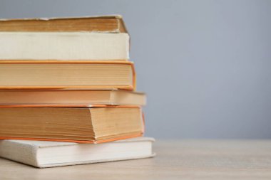 Tahta masadaki kitap yığını.
