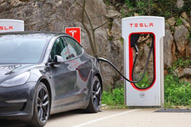Hırvatistan 'ın Vrgorac kenti, istasyonda 17.03.Tesla elektrikli araba, yolda kırmızı elektrikli araba şarj ediliyor, Tesla arabası şarj ediliyor 