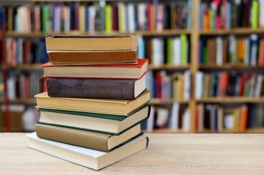 Tahta masadaki kitap yığını.