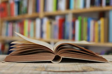 Bulanık arka plana karşı ahşap masadaki kitap yığını