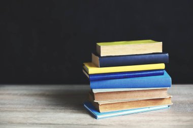 Tahta masadaki kitap yığını.