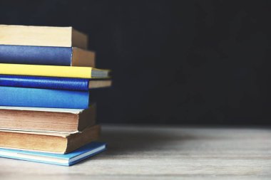 Tahta masadaki kitap yığını.