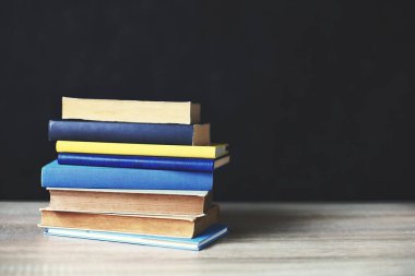 Tahta masadaki kitap yığını.