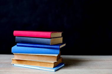 Tahta masadaki kitap yığını.