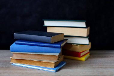 Bulanık arkaplana karşı masadaki kitap yığını