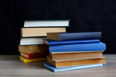 Tahta masadaki kitap yığını.