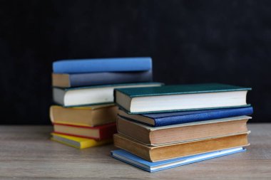 Kara tahta bir masanın üzerindeki kitaplar, bir yığın kitap. Okula geri dön..