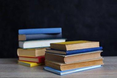 Bulanık arka plana karşı ahşap masanın üzerinde kitap yığını. Metin için boşluk