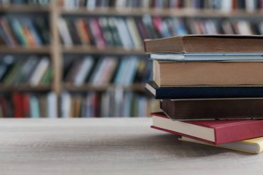 Tahta masadaki kitap yığını.