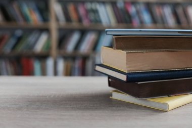 Ahşap masada yığınla kitap ve bardak var. eğitim