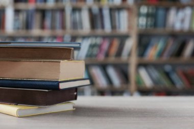 Tahta masadaki kitap yığını.