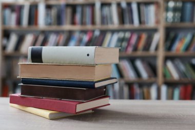 Tahta masadaki kitap yığını.