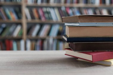 Tahta masadaki kitap yığını.