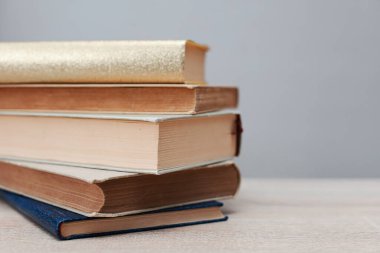 Tahta masanın üzerinde bir yığın kitap var.