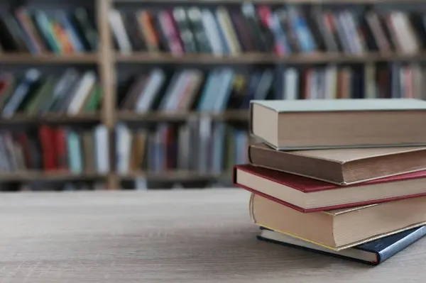 Kütüphanedeki masanın üzerinde kitap yığını
