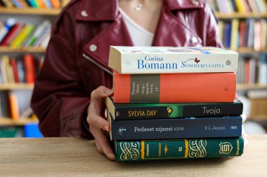 Kütüphanede kitapları olan kadın öğrenci.