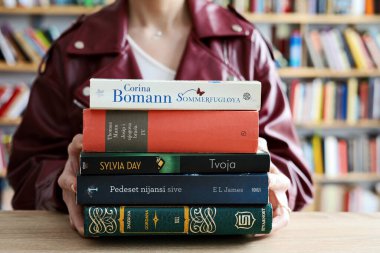 Kütüphanede kitap okuyan genç bir kadın. eğitim kavramı