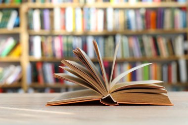 Kitaplar ahşap rafta. Düzgün sıralanmış kitaplar. Kütüphanelerdeki rafların çoğunda kitabın omurgasında (numaralar, kodlar veya etiketler) net işaretler bulunan boy, konu veya türe göre düzenlenmiş kitaplar vardır. Kütüphaneler sessiz yerlerdir.