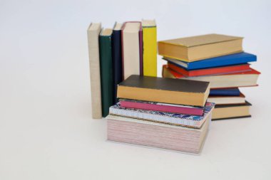 Siyah arka plan üzerine bir yığın kitap, düzgünce düzenlenmiş kitaplar. Kütüphanelerdeki rafların çoğunda kitabın omurgasında (numaralar, kodlar veya etiketler) net işaretler bulunan boy, konu veya türe göre düzenlenmiş kitaplar vardır. Kütüphaneler sessiz yerlerdir.