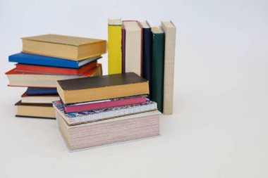 Siyah arka plan üzerine bir yığın kitap, düzgünce düzenlenmiş kitaplar. Kütüphanelerdeki rafların çoğunda kitabın omurgasında (numaralar, kodlar veya etiketler) net işaretler bulunan boy, konu veya türe göre düzenlenmiş kitaplar vardır. Kütüphaneler sessiz yerlerdir.