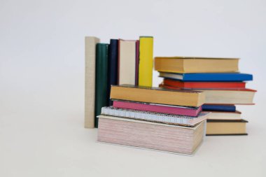 Siyah arka plan üzerine bir yığın kitap, düzgünce düzenlenmiş kitaplar. Kütüphanelerdeki rafların çoğunda kitabın omurgasında (numaralar, kodlar veya etiketler) net işaretler bulunan boy, konu veya türe göre düzenlenmiş kitaplar vardır. Kütüphaneler sessiz yerlerdir.