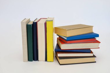 Siyah arka plan üzerine bir yığın kitap, düzgünce düzenlenmiş kitaplar. Kütüphanelerdeki rafların çoğunda kitabın omurgasında (numaralar, kodlar veya etiketler) net işaretler bulunan boy, konu veya türe göre düzenlenmiş kitaplar vardır. Kütüphaneler sessiz yerlerdir.