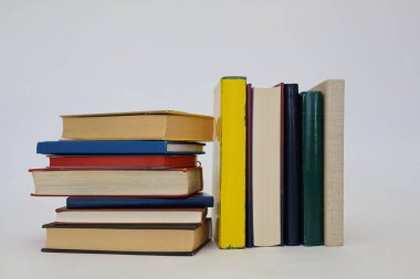 Siyah arka plan üzerine bir yığın kitap, düzgünce düzenlenmiş kitaplar. Kütüphanelerdeki rafların çoğunda kitabın omurgasında (numaralar, kodlar veya etiketler) net işaretler bulunan boy, konu veya türe göre düzenlenmiş kitaplar vardır. Kütüphaneler sessiz yerlerdir.