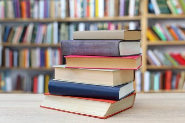 Siyah arka plan üzerine bir yığın kitap, düzgünce düzenlenmiş kitaplar. Kütüphanelerdeki rafların çoğunda kitabın omurgasında (numaralar, kodlar veya etiketler) net işaretler bulunan boy, konu veya türe göre düzenlenmiş kitaplar vardır. Kütüphaneler sessiz yerlerdir.