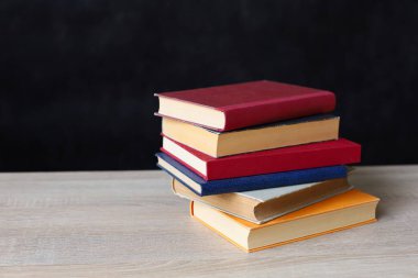 Siyah arka plan üzerine bir yığın kitap, düzgünce düzenlenmiş kitaplar. Kütüphanelerdeki rafların çoğunda kitabın omurgasında (numaralar, kodlar veya etiketler) net işaretler bulunan boy, konu veya türe göre düzenlenmiş kitaplar vardır. Kütüphaneler sessiz yerlerdir.