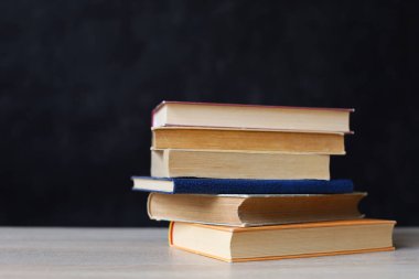 Siyah arka plan üzerine bir yığın kitap, düzgünce düzenlenmiş kitaplar. Kütüphanelerdeki rafların çoğunda kitabın omurgasında (numaralar, kodlar veya etiketler) net işaretler bulunan boy, konu veya türe göre düzenlenmiş kitaplar vardır. Kütüphaneler sessiz yerlerdir.