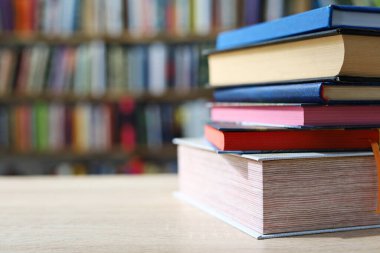 Siyah arka plan üzerine bir yığın kitap, düzgünce düzenlenmiş kitaplar. Kütüphanelerdeki rafların çoğunda kitabın omurgasında (numaralar, kodlar veya etiketler) net işaretler bulunan boy, konu veya türe göre düzenlenmiş kitaplar vardır. Kütüphaneler sessiz yerlerdir.