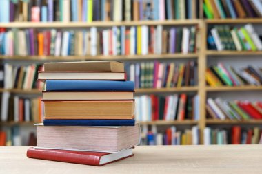 Siyah arka plan üzerine bir yığın kitap, düzgünce düzenlenmiş kitaplar. Kütüphanelerdeki rafların çoğunda kitabın omurgasında (numaralar, kodlar veya etiketler) net işaretler bulunan boy, konu veya türe göre düzenlenmiş kitaplar vardır. Kütüphaneler sessiz yerlerdir.