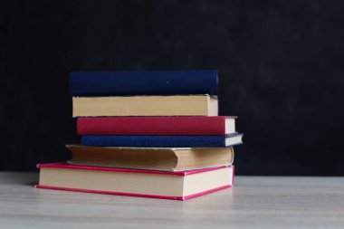 Siyah arka plan üzerine bir yığın kitap, düzgünce düzenlenmiş kitaplar. Kütüphanelerdeki rafların çoğunda kitabın omurgasında (numaralar, kodlar veya etiketler) net işaretler bulunan boy, konu veya türe göre düzenlenmiş kitaplar vardır. Kütüphaneler sessiz yerlerdir.